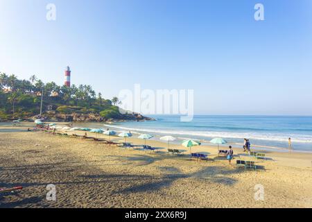 Kovalam, India, 1 marzo 2015: Sedie e ombrelloni da spiaggia fiancheggiano la spiaggia sulla sabbia, in vista delle onde dell'oceano a Kovalam Light House Beach in Kerala Foto Stock