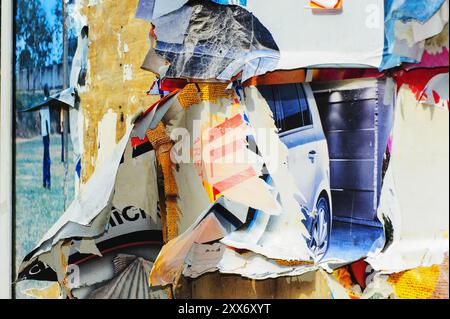 Poster strappati su un vecchio cartellone Foto Stock