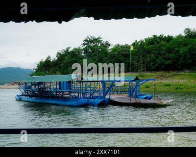 Traghetto locale che trasporta auto, moto e persone attraverso un fiume nella provincia di Kanchanaburi, Thailandia. Foto Stock