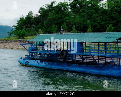 Traghetto locale che trasporta auto, moto e persone attraverso un fiume nella provincia di Kanchanaburi, Thailandia. Foto Stock