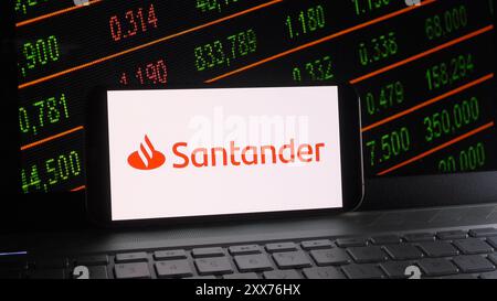 Cina. 23 agosto 2024. In questa illustrazione fotografica, il logo Banco Santander viene visualizzato su uno smartphone con una borsa e uno sfondo della tastiera di un notebook. Credito: SOPA Images Limited/Alamy Live News Foto Stock