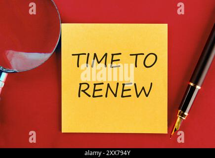 Tempo concettuale per rinnovare il concetto. Copia spazio. È il momento di rinnovare le parole scritte su un adesivo giallo su uno sfondo rosso saturo Foto Stock