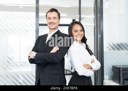 Un team aziendale sicuro di sé, pronto ad affrontare le sfide con un sorriso e una professionalità Foto Stock