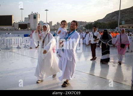 Mecca, Arabia Saudita - 8 giugno 2024: Una famiglia felice con il loro bambino che fa Hajj e Umrah che camminano vicino a Masjidil Haram, grande Moschea della Mecca. Hajj 202 Foto Stock