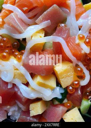 Chirashi Sushi Don, riso misto coperto di pesce, condimento con pesce crudo, riso giapponese al vapore, salmone, Maguro e Tamago, uova di salmone, calamari, zucchine, Foto Stock