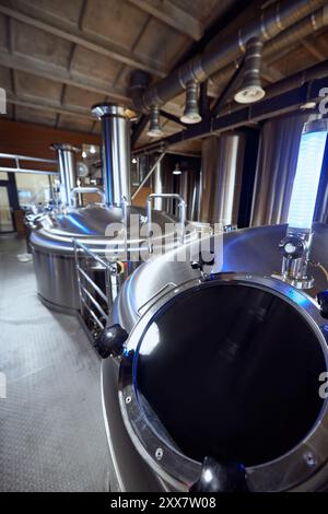 I serbatoi in acciaio inossidabile del birrificio, con le loro valvole avanzate, mettono in evidenza l'esperienza tecnica richiesta nella produzione di birra moderna. Foto Stock