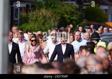 I lutti camminano dietro la carrozza trainata da cavalli che porta la bara della vittima pugnalatrice di Southport Elsie Dot Stancombe, mentre il corteo si reca al suo funerale nella chiesa di St John a Birkdale. Il bambino di sette anni è morto in un attacco di coltello durante una lezione di danza a Southport il 29 luglio. Data foto: Venerdì 23 agosto 2024. Foto Stock