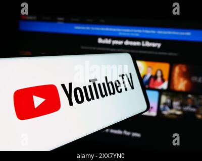 Smartphone con logo del servizio IPTV americano YouTube TV davanti al sito Web dell'azienda. Mettere a fuoco la parte centrale sinistra del display del telefono. Foto Stock