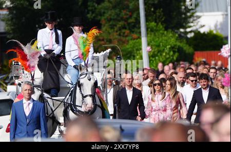 I lutti camminano dietro la carrozza trainata da cavalli che porta la bara della vittima pugnalatrice di Southport Elsie Dot Stancombe, mentre il corteo si reca al suo funerale nella chiesa di St John a Birkdale. Il bambino di sette anni è morto in un attacco di coltello durante una lezione di danza a Southport il 29 luglio. Data foto: Venerdì 23 agosto 2024. Foto Stock