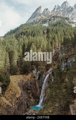 Cascata che si snoda tra le montagne boscose del Rosenlaui Canyon Foto Stock