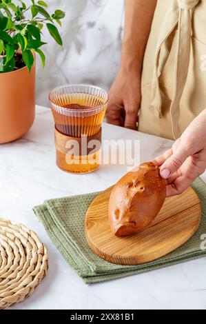 una ragazza tiene una torta fatta in casa riempendosi le mani Foto Stock