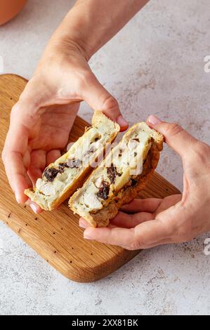 una ragazza tiene una torta fatta in casa riempendosi le mani Foto Stock