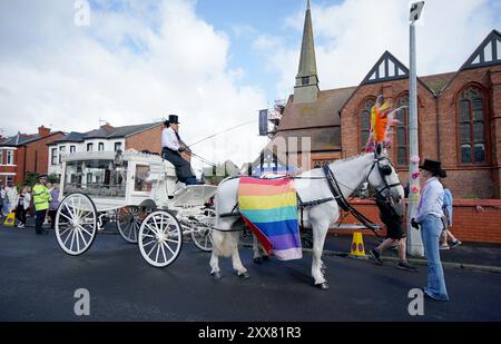 La carrozza trainata da cavalli che trasportava la bara della vittima pugnalatrice di Southport Elsie Dot Stancombe attende fuori dalla chiesa di St John a Birkdale durante il suo funerale. Il bambino di sette anni è morto in un attacco di coltello durante una lezione di danza a Southport il 29 luglio. Data foto: Venerdì 23 agosto 2024. Foto Stock