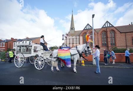 La carrozza trainata da cavalli che trasportava la bara della vittima pugnalatrice di Southport Elsie Dot Stancombe attende fuori dalla chiesa di St John a Birkdale durante il suo funerale. Il bambino di sette anni è morto in un attacco di coltello durante una lezione di danza a Southport il 29 luglio. Data foto: Venerdì 23 agosto 2024. Foto Stock