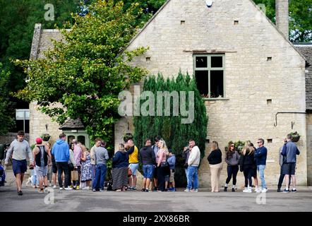 Gente che fa la fila all'aperto del nuovo pub di Jeremy Clarkson, il Farmer's Dog, ad Asthall, vicino a Burford nell'Oxfordshire. Data foto: Venerdì 23 agosto 2024. Foto Stock