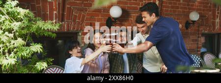 Giovani, uomini e donne sorridenti e felici, amici che si riuniscono al bar all'aperto in una calda serata soleggiata e gustando una birra rinfrescante. Ciao. Foto Stock