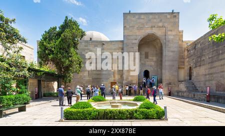 Baku, Azerbaigian - 10 maggio 2024: I turisti si riuniscono nel cortile del Palazzo degli Shirvanshah, ammirando l'architettura e la ricca storia Foto Stock