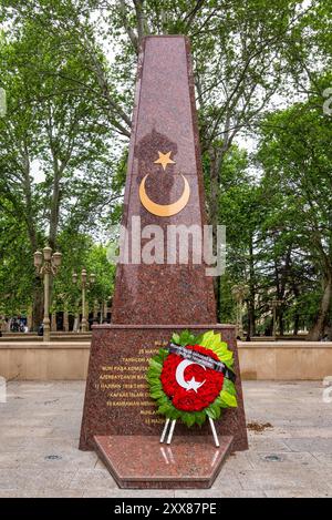 Ganja, Azerbaigian - 13 maggio 2024: Il Memoriale dei Martiri turchi, un obelisco di granito rosso dedicato alla memoria dei soldati turchi morti durante la prima guerra mondiale Foto Stock