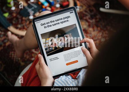Parigi, Francia - 11 giugno 2023: Una donna che legge su Apple Vision Pro su un tablet durante il suo lancio, con lo schermo che ne evidenzia le caratteristiche per migliorare le riunioni virtuali e la collaborazione Foto Stock