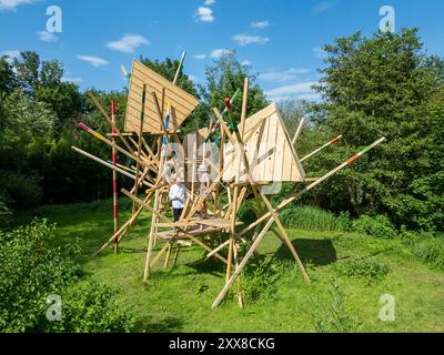 Francia, somme, Amiens, hortillonnages, ifestival internazionale del giardino, Clermont Pond, l'archivio acquatico Scultura di Vincent Bredif e Julien Fajardo (2024), presentazione a un visitatore dell'opera di Gilbert Fillinger (a sinistra), fondatore del festival Amiens hortillonnages Foto Stock