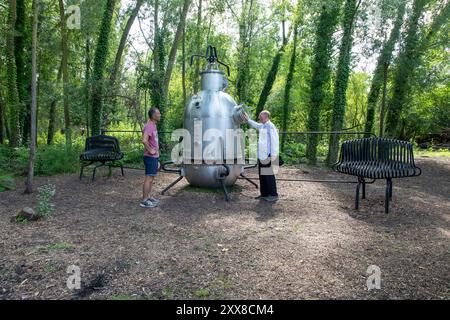 Francia, somme, Amiens, hortillonnages, festival internazionale del giardino, Clermont Pond, “Thermo V3”, opera in plastica di Francesco Dufeil (2024), presentazione a un visitatore dell'opera di Gilbert Fillinger (a destra), fondatore del festival Amiens hortillonnages Foto Stock