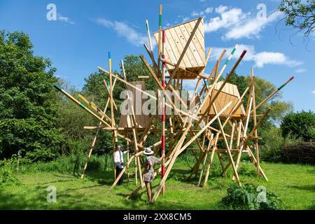 Francia, somme, Amiens, hortillonnages, ifestival internazionale del giardino, Clermont Pond, l'archivio acquatico Scultura di Vincent Bredif e Julien Fajardo (2024), presentazione a un visitatore dell'opera di Gilbert Fillinger (a sinistra), fondatore del festival Amiens hortillonnages Foto Stock