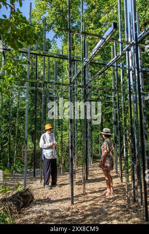 Francia, somme, Amiens, hortillonnages, ifestival internazionale del giardino, island of Fagots, “le Pittoresque”, opera plastica di Gilles Brusset (2024), presentazione a un visitatore del lavoro di Gilbert Fillinger (a sinistra), fondatore del festival Amiens hortillonnages Foto Stock