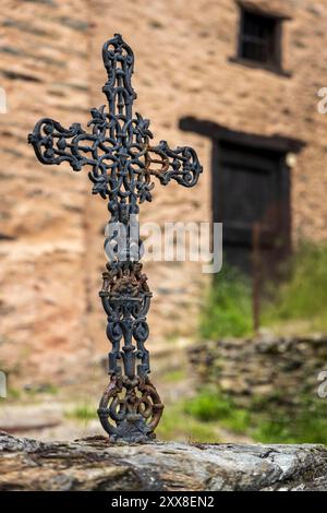 Francia, Aveyron, Conques, etichettato Plus Beaux Villages de France, croce di ferro battuto sigillata su un muro di un vicolo del villaggio medievale Foto Stock