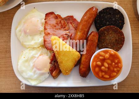 Colazione irlandese. Pasto mattutino tradizionale con salsiccia, pancetta, funghi, uova fritte, crocchette di patate e fagioli. Foto Stock