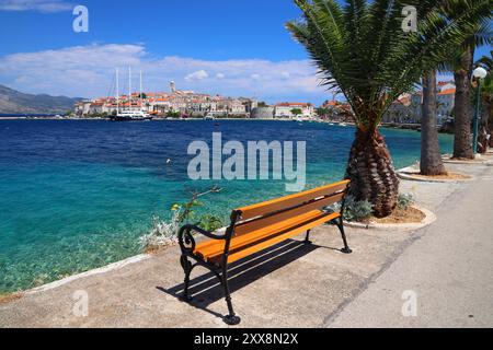 Croazia città di Korcula. Città fortificata medievale sull'isola di Korcula. Passeggiata sul lungomare con panchine. Foto Stock