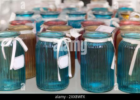 I vasi in vetro colorato sono venduti in negozio. Vasi per mazzi di fiori. Foto Stock