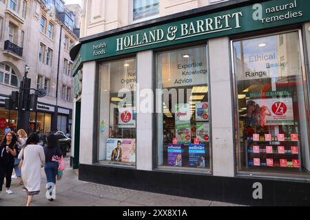 LONDRA, Regno Unito - 14 LUGLIO 2019: People Walk by Holland e Barrett store a Londra. Olanda e Barrett è una catena di rimedio naturale e cibo sano stor Foto Stock