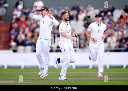 L'inglese Chris Woakes (centro) celebra il wicket dello Sri Lanka Nishan Madushka (non in foto) con i compagni di squadra Ollie Pope (a sinistra) e Matthew Potts durante il terzo giorno del primo Rothesay test match all'Emirates Old Trafford di Manchester. Data foto: Venerdì 23 agosto 2024. Foto Stock