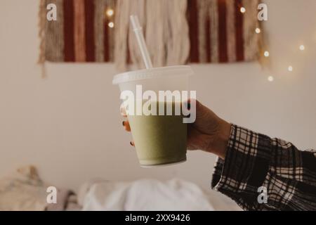 persone che tengono la tazza con la cannuccia di latte matcha Foto Stock