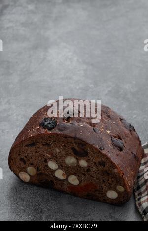 Pane dolce di segale con nocciole e frutta secca su un tavolo grigio Foto Stock