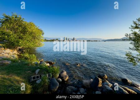 Paesaggio estivo con il lago Okanagan e il centro di Kelowna in lontananza sotto un cielo blu Foto Stock