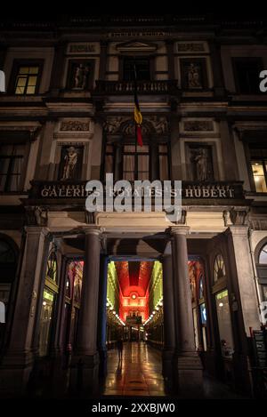 Ingresso alle Galeries Royales Saint-Hubert illuminato di notte con bandiera belga - Bruxelles, Belgio Foto Stock