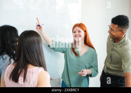 Lavoro di squadra professionale di giovani che discutono strategie aziendali e brainstorming in ufficio utilizzando la lavagna Foto Stock