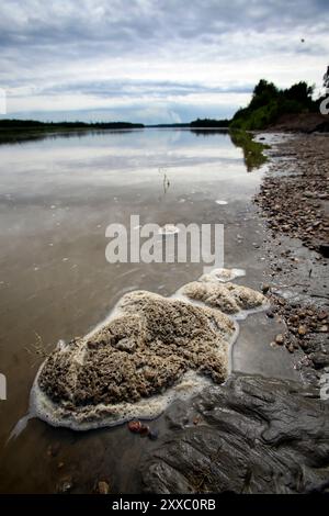 Schiuma sulla superficie di un fiume confinanti con i bacini di decantazione degli sterili sono utilizzati dalle compagnie petrolifere per depositare i rifiuti tossici. Il Chipewyan banda di prima nazione che vive a Fort McKay sono preoccupati per l'impatto ambientale di consentire la sabbia di olio le aziende ad operare nel loro quartiere. Foto Stock