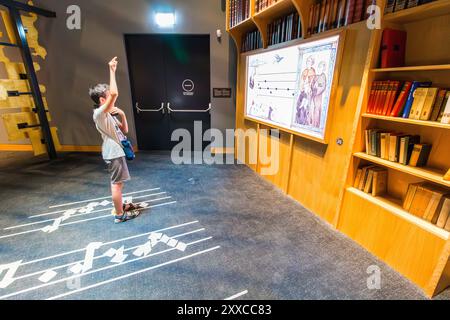 Bambino che suona (suonando musica medievale sollevando il braccio) in House of Music (A Magyar Zene Haza), Varosliget, Budapest, Ungheria Foto Stock