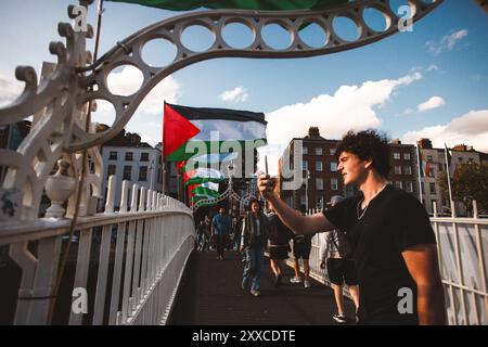 Dublino, North Dublin City, Irlanda. 23 agosto 2024. 23 AGOSTO 2024. I turisti si vedono scattare selfie con bandiere palestinesi con uno striscione che recita "Irish stands with Palestine" mentre sono esposti sullo sfondo sopra il ponte Ha'penny di Dublino. L'azione, organizzata dalla campagna di solidarietà Irlanda-Palestina (IPSC), ha protestato contro quello che hanno descritto come il genocidio israeliano in corso a Gaza contro il popolo palestinese. (Credit Image: © Eman Mohammed/ZUMA Press Wire) SOLO PER USO EDITORIALE! Non per USO commerciale! Foto Stock