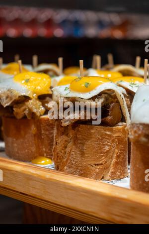 Spuntini tipici dei Paesi Baschi, spiedini di pinchos o pinxtos con piccoli pezzi di pane, pesce, frutti di mare, uova fritte serviti al bar di San Sebastian o. Foto Stock