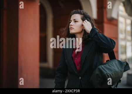 Giovane donna d'affari in costume da bagno elegante che cammina all'aperto con sicurezza Foto Stock