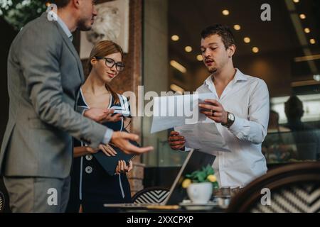 Professionisti aziendali che discutono di strategie di vendita e analizzano i report di crescita in un ufficio moderno con un lavoro di squadra impegnato Foto Stock