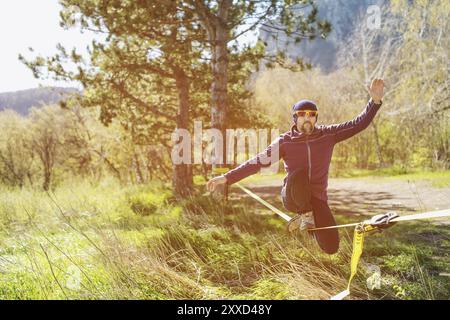 Un uomo all'età di sedersi su una linea lenta, trovare equilibrio e godersi la vita Foto Stock