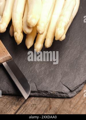 Asparagi bianchi al buio su un scheda di ardesia, alimento stagionale Foto Stock