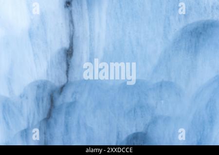 Primo piano muro sfocato di un ghiacciaio secolare con una struttura di strisce e bolle. Struttura chiara blu ghiaccio Foto Stock