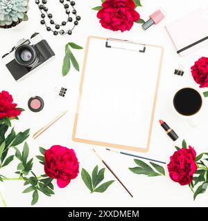 Spazio di lavoro femminile con diario, fotocamera retrò, fiori di peonie, appunti e accessori su sfondo bianco. Disposizione piatta, vista dall'alto. Copia spazio Foto Stock