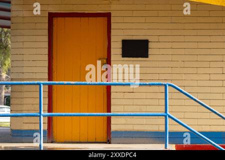 sportello giallo con bordo rosso e dettagli blu Foto Stock