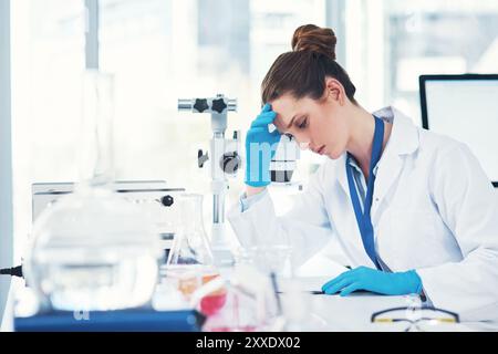 Stanca, donna o scienziata in laboratorio con studio scientifico per la ricerca per testare sperimentare con scadenza o stress. Mal di testa, fisico esausto o scrittura Foto Stock